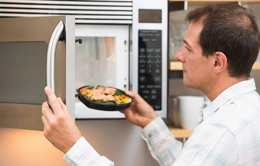 Man microwaving processed meal