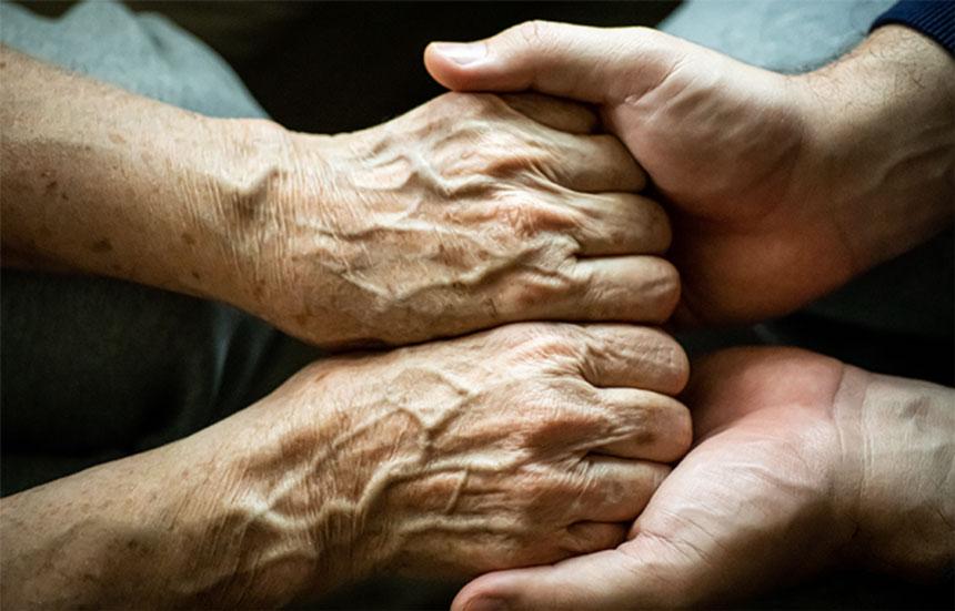 Two people comforting each other by holding hands.