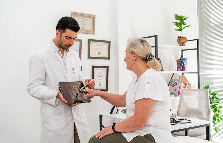 Male physician with female patient explaining spinal scan