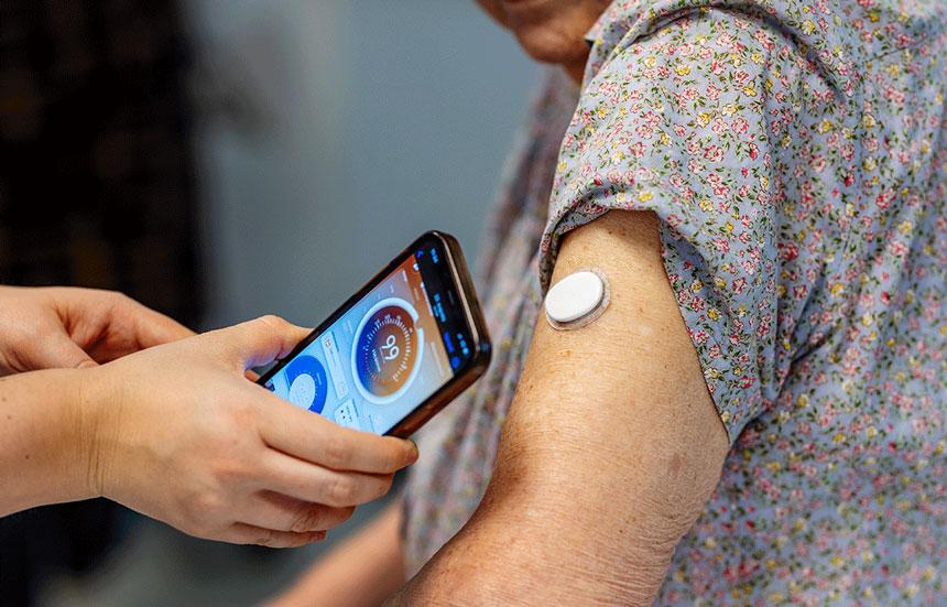 nurse teaching older woman how to use a CGM