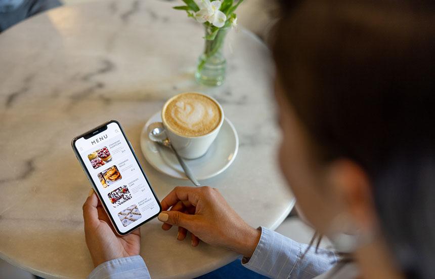 Coffee house patron looking at nutrition facts mobile app