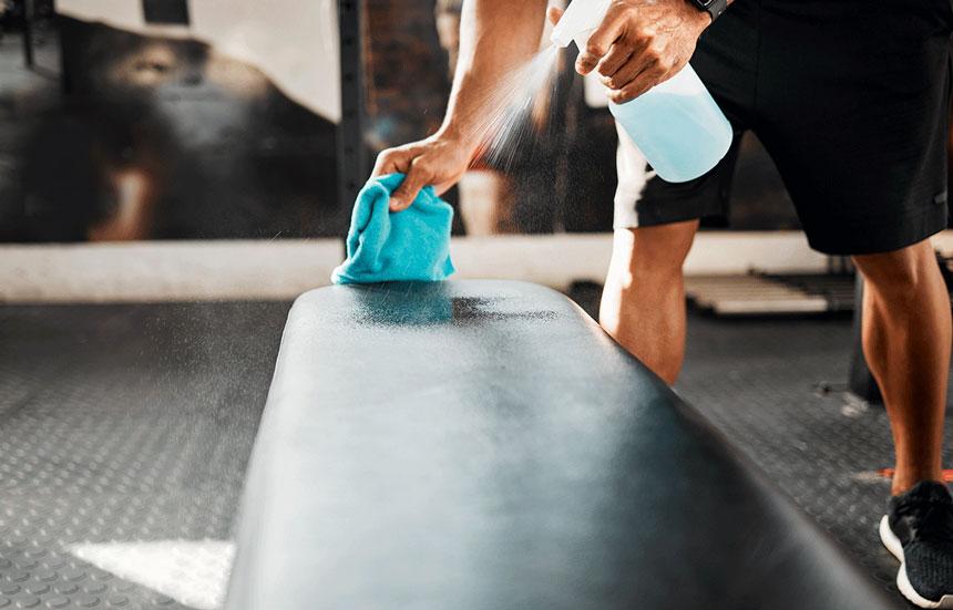 Wiping down bench in fitness center