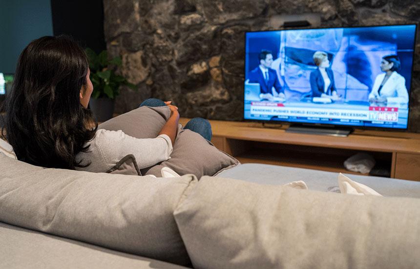 Women on a couch watching the news