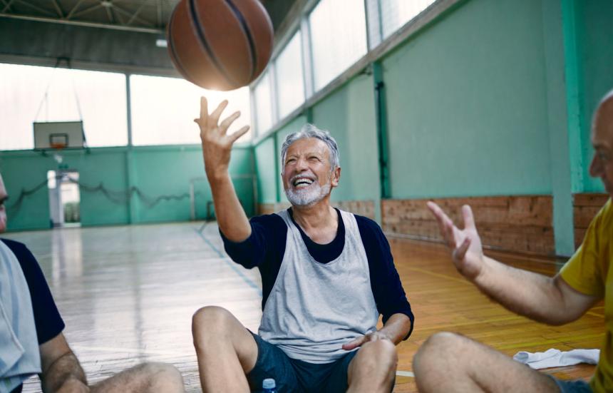 middle aged man tossing basketball into the air