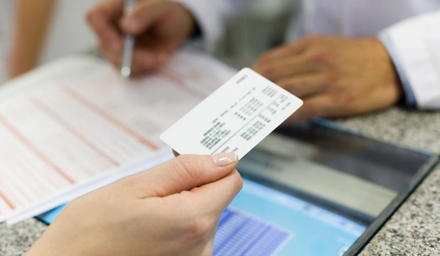 patient handing insurance card to a physician