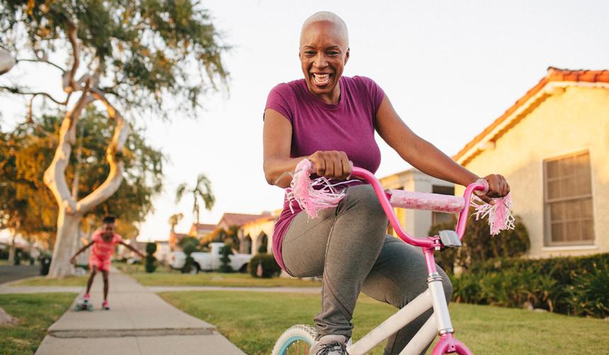 Grandmother riding tricycle with granddaughter.