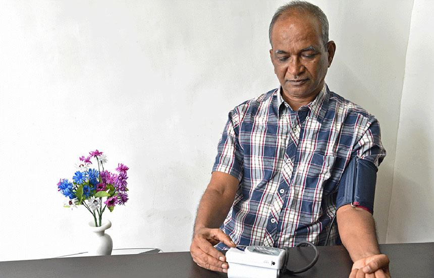 Man using a home blood pressure machine