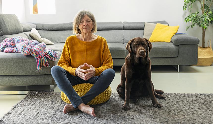 A woman and her dog practicing mindful meditation.