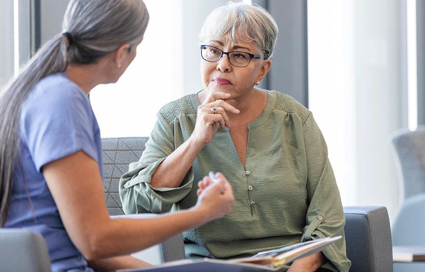 Post-menopausal female patient talking to doctor