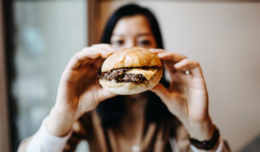 A woman eating a hamburger.