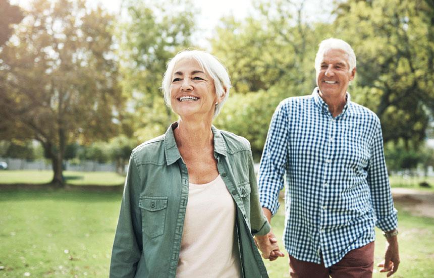 Older couple walking together in park