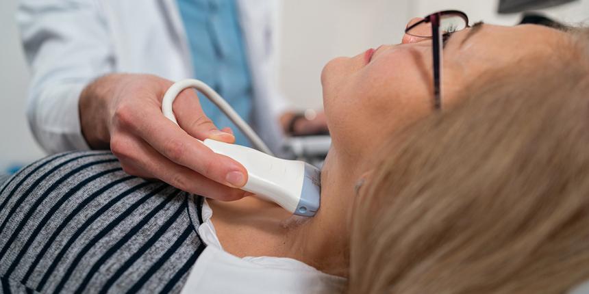 A doctor performs a thyroid ultrasound.