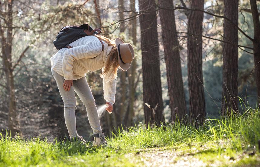 woman spraying insect repellant