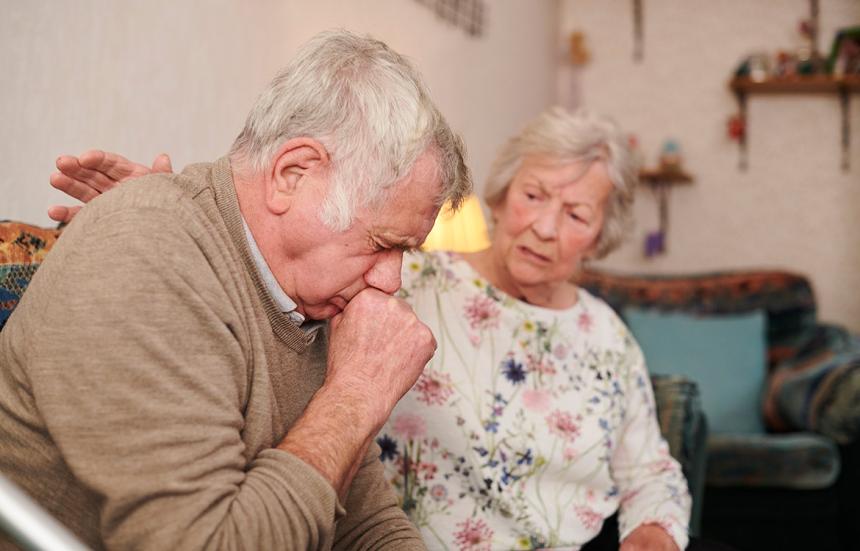 woman comforting man who is coughing