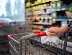 Woman wiping down grocery cart in supermarket