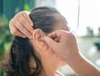 Woman putting on a hearing aid