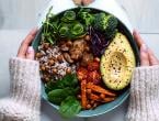 Woman eating a plate of vegetables. Plant-based diets have substantial health benefits.