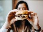 A woman eating a hamburger.