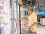 shopper opening fridge door in grocery store